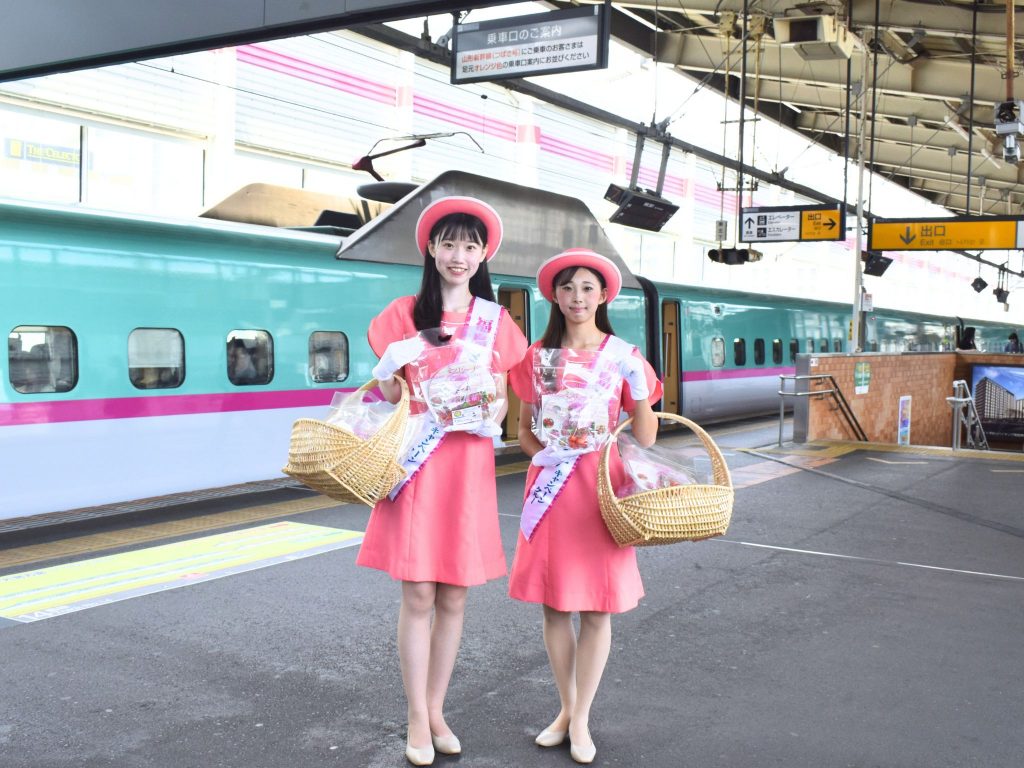 福島駅新幹線ホームで東北新幹線やまびこの前にミスピーチキャンペーンクルーが2名立っている